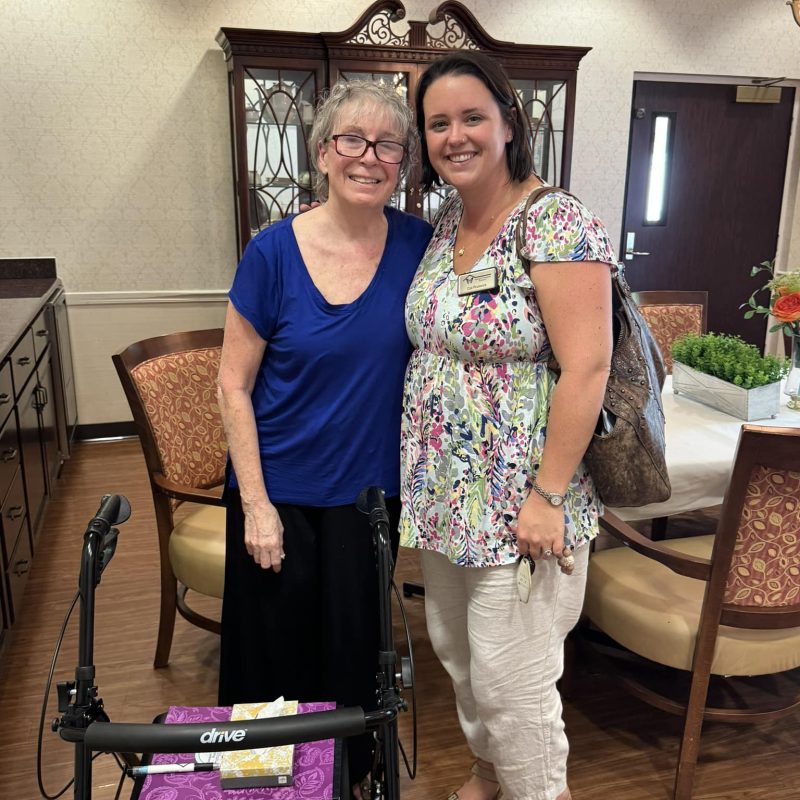 Cat stands with a senior woman after signing title papers freeing up equity to put a deposit down on her new senior living community home in St. Pete, Florida.